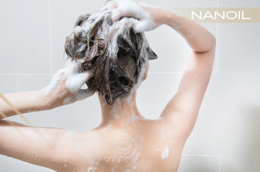 Žena uprostred sprchovania, nanášanie šampónu